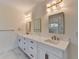 Well-lit bathroom with double sinks, marble countertops, stylish fixtures, and framed mirrors at 5533 Addison Woods Pl, Buford, GA 30518