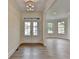 Bright entryway with wood floors, white trim, and a modern light fixture, leading into the living areas at 5533 Addison Woods Pl, Buford, GA 30518