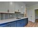 Modern kitchenette featuring stainless steel appliances, sleek countertops, and stylish blue and white cabinetry at 5533 Addison Woods Pl, Buford, GA 30518