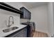 Well-organized laundry room with front-load machines, cabinetry, quartz countertops, and a convenient sink at 5533 Addison Woods Pl, Buford, GA 30518