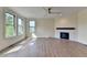 Bright living room featuring a fireplace, large windows, and modern ceiling fan at 5533 Addison Woods Pl, Buford, GA 30518