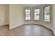 Bright, light-filled room with wood floors, bay windows, and neutral wall colors at 5533 Addison Woods Pl, Buford, GA 30518