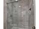 Modern shower with glass door and stylish gray tiling with niche for soaps at 5533 Addison Woods Pl, Buford, GA 30518