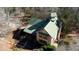 Aerial view of a charming home with a unique turret and green metal roof nestled in a wooded lot at 5642 N Highway 212, Covington, GA 30016