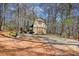 Exterior view of the quaint barn with covered porch enveloped by a tranquil, wooded landscape at 5642 N Highway 212, Covington, GA 30016