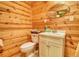 Wood paneled bathroom with a toilet and cabinet style vanity at 5642 N Highway 212, Covington, GA 30016