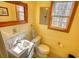 Well-lit bathroom features a vanity with sink, toilet, and a window at 5642 N Highway 212, Covington, GA 30016