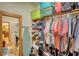 Walk-in closet with an ironing board, shelves, and multiple clothing items at 5642 N Highway 212, Covington, GA 30016