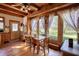 Sun-filled dining area featuring wood floors, wooden beams, and large windows with serene backyard views at 5642 N Highway 212, Covington, GA 30016