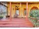 Covered front porch with ceiling fan, seating, and a unique wooden door at 5642 N Highway 212, Covington, GA 30016