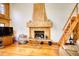 Cozy living room features a grand stone fireplace, wooden floors, and a ladder to a loft area at 5642 N Highway 212, Covington, GA 30016