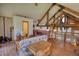 Cozy room featuring wood floors, exposed beams, a futon, and access to a loft area at 5642 N Highway 212, Covington, GA 30016