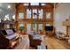 Spacious living room featuring wood walls, beamed ceilings, a leather couch, and many windows at 5642 N Highway 212, Covington, GA 30016