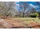 View of well-maintained lawn and surrounding mature trees on a partly cloudy day at 5642 N Highway 212, Covington, GA 30016