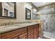 Main bathroom featuring double sink vanity with granite counters and tiled glass shower at 1850 Westwind Dr, Cumming, GA 30041