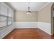 Elegant dining room with hardwood floors, wainscoting, and a modern light fixture at 1850 Westwind Dr, Cumming, GA 30041