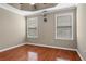 Bright main bedroom featuring hardwood floors, two windows, and a ceiling fan at 1850 Westwind Dr, Cumming, GA 30041