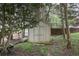 Property features a functional outdoor shed on a large lot, perfect for storage, nestled among trees at 1850 Westwind Dr, Cumming, GA 30041