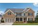 Charming two-story brick home featuring black shutters, a red front door, and a well-manicured lawn at 4776 Trilogy Park Trl, Hoschton, GA 30548