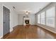 Bright living room showcasing hardwood floors, fireplace, and large windows for ample natural light at 4776 Trilogy Park Trl, Hoschton, GA 30548