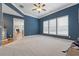Spacious living room with neutral carpet, blue walls, and an open doorway to other rooms at 4776 Trilogy Park Trl, Hoschton, GA 30548