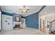 Inviting living room with custom built-ins flanking a fireplace and a modern ceiling fan at 4776 Trilogy Park Trl, Hoschton, GA 30548