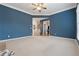 Spacious living room with neutral carpet, blue walls, and an open doorway to the entry foyer at 4776 Trilogy Park Trl, Hoschton, GA 30548