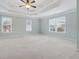 Spacious main bedroom with a tray ceiling, ceiling fan, and large windows for natural light at 4776 Trilogy Park Trl, Hoschton, GA 30548