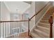 Carpeted staircase with wooden handrail and open landing featuring a chandelier at 4776 Trilogy Park Trl, Hoschton, GA 30548