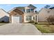 Charming two-story home featuring stone accents, attached garage, and well-maintained lawn at 6439 Grey Fox Way, Riverdale, GA 30296