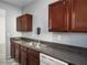 Kitchen featuring wooden cabinets, stone counters, and a stainless steel sink and dishwasher at 6439 Grey Fox Way, Riverdale, GA 30296