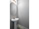 Small powder room with pedestal sink, oval mirror, and modern light fixture at 6439 Grey Fox Way, Riverdale, GA 30296