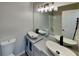 Bathroom showcasing double vessel sinks, modern lighting, and a large mirror at 7021 Hillcrest Chase Ln, Austell, GA 30168