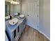 Bathroom featuring dual sinks, modern cabinets, mirrors and a tiled floor at 7021 Hillcrest Chase Ln, Austell, GA 30168