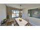 Virtually staged dining room features new flooring and a hanging light fixture at 7021 Hillcrest Chase Ln, Austell, GA 30168