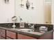 Bathroom vanity featuring granite countertop, decorative sconces, and framed mirror at 200 River Vista Dr # 736, Atlanta, GA 30339
