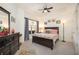 Comfortable bedroom with a ceiling fan, tray ceiling, large window, and a large dresser at 200 River Vista Dr # 736, Atlanta, GA 30339