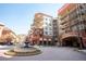 Beautiful condo building featuring multiple balconies, brick accents, and a landscaped roundabout with fountain at 200 River Vista Dr # 736, Atlanta, GA 30339