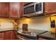 Close up of kitchen with stainless steel appliances, stone backsplash, and elegant dark wood cabinetry at 200 River Vista Dr # 736, Atlanta, GA 30339