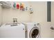 Laundry room with white front-load washer and dryer and storage shelving at 200 River Vista Dr # 736, Atlanta, GA 30339