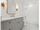 Modern bathroom features a gray vanity, gold fixtures, and a shower with white geometric tile at 375 Chattahoochee St, Roswell, GA 30075