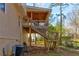 Backyard view of a raised wooden deck with stairs, attached to a home with tan siding at 47 Greatwood Dr, White, GA 30184