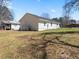 Expansive backyard featuring a home's rear facade, showing a lush lawn and neighboring structures under a sunny sky at 1190 Dallas Hwy, Villa Rica, GA 30180