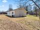 View of a house featuring a level grassy backyard with a small deck area and several neighboring buildings at 1190 Dallas Hwy, Villa Rica, GA 30180