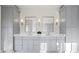 Elegant bath featuring gray vanity with double sinks, stylish mirrors and lighting, and marble floors at 2849 Parkridge Ne Dr, Brookhaven, GA 30319