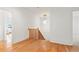 Hallway with white walls, hardwood floors, wood stair railing, and a modern light fixture at 2849 Parkridge Ne Dr, Brookhaven, GA 30319