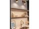 Close-up of a kitchen sink with gold faucet and decorative shelves featuring vases and a framed picture at 2849 Parkridge Ne Dr, Brookhaven, GA 30319