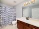 Bathroom with tile floors, dark cabinets, and gray geometric shower curtain at 6675 Princeton Park Ct, Lithonia, GA 30058