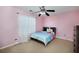 Bright bedroom featuring pink walls, ceiling fan and carpet at 6675 Princeton Park Ct, Lithonia, GA 30058
