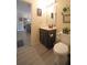 Bathroom with dark-stained vanity, framed art, soft lighting and toilet at 9348 Lantana Trl, Jonesboro, GA 30238